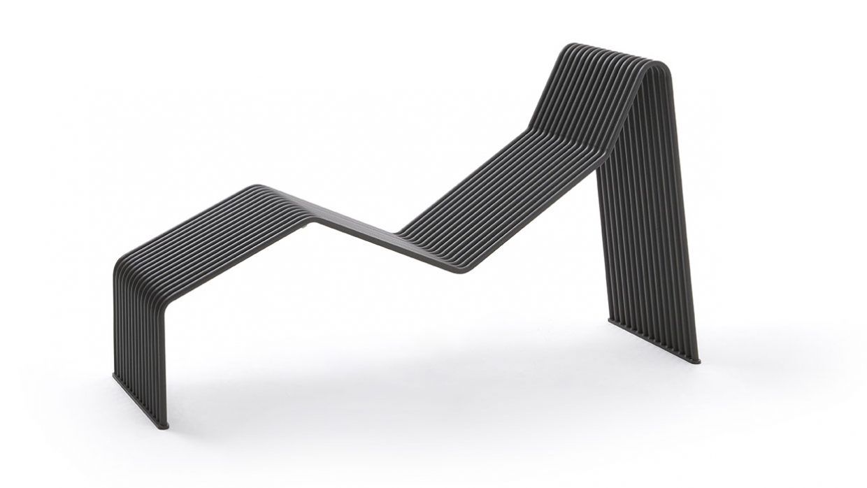 Una silla negra con un patrón de rayas está colocada sobre una superficie blanca.