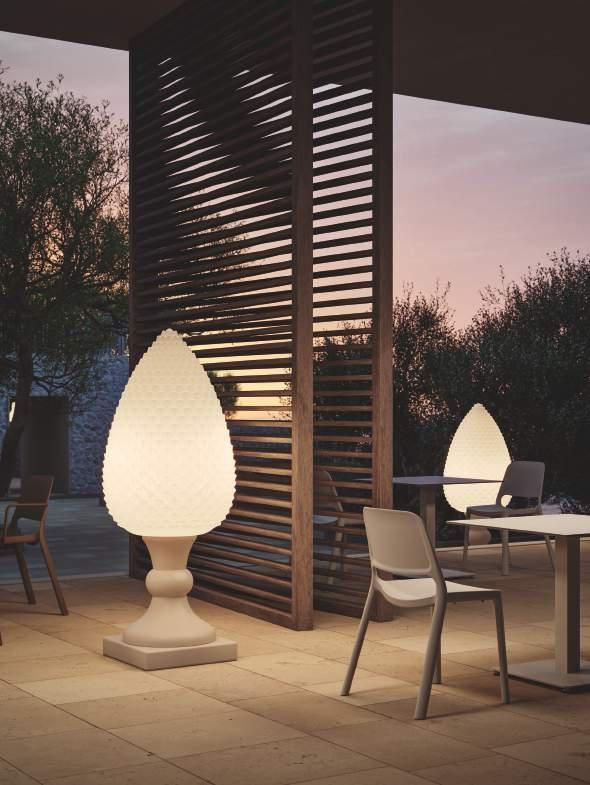 Un patio con mesas y sillas y una lámpara en forma de piña.