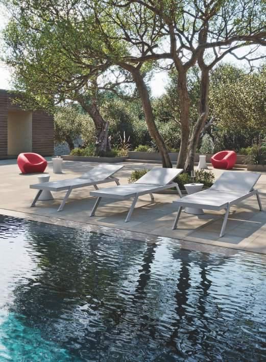 Una fila de tumbonas junto a una piscina.