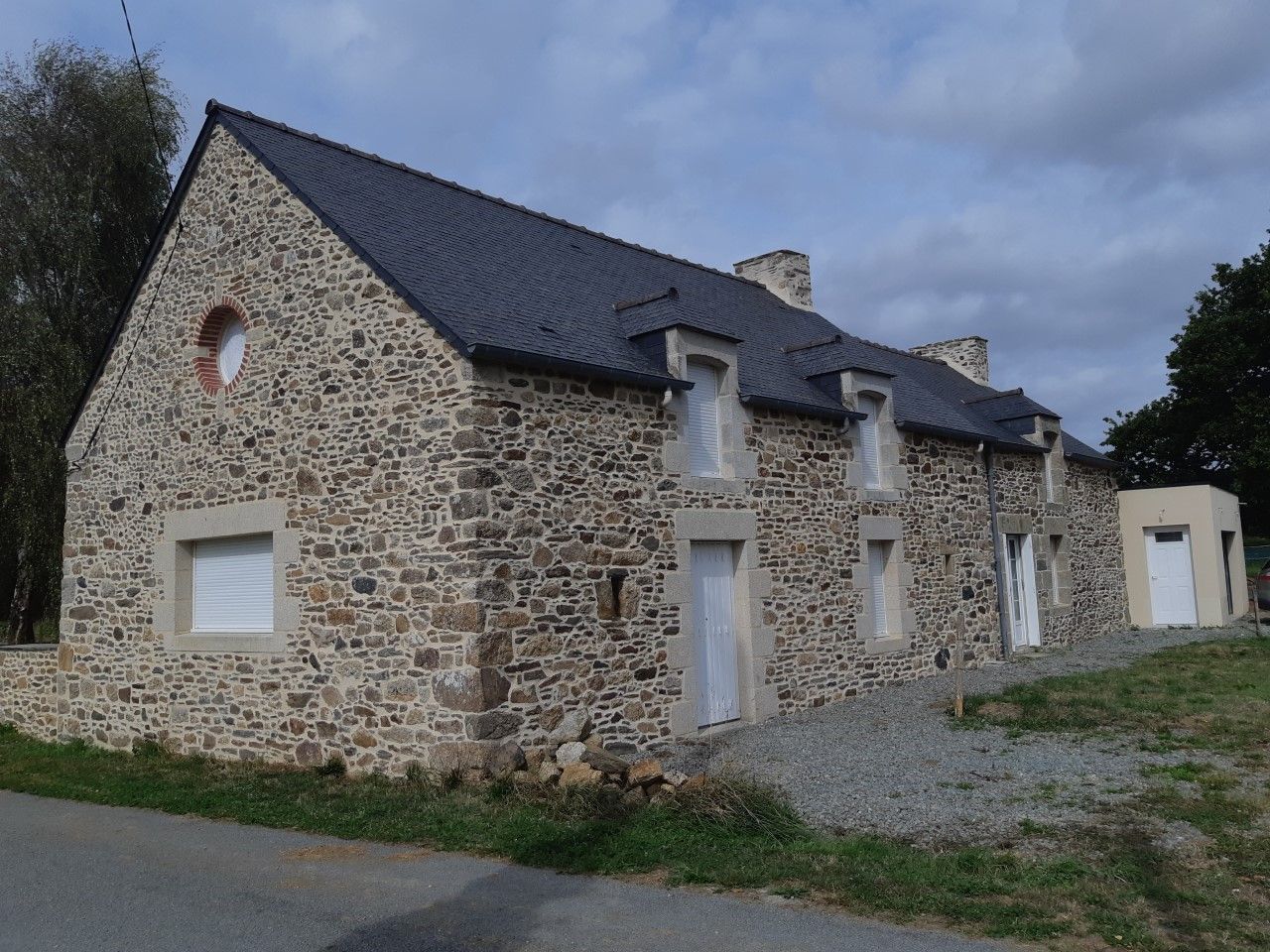 Maison en pierre avec menuiserie extérieure blanche