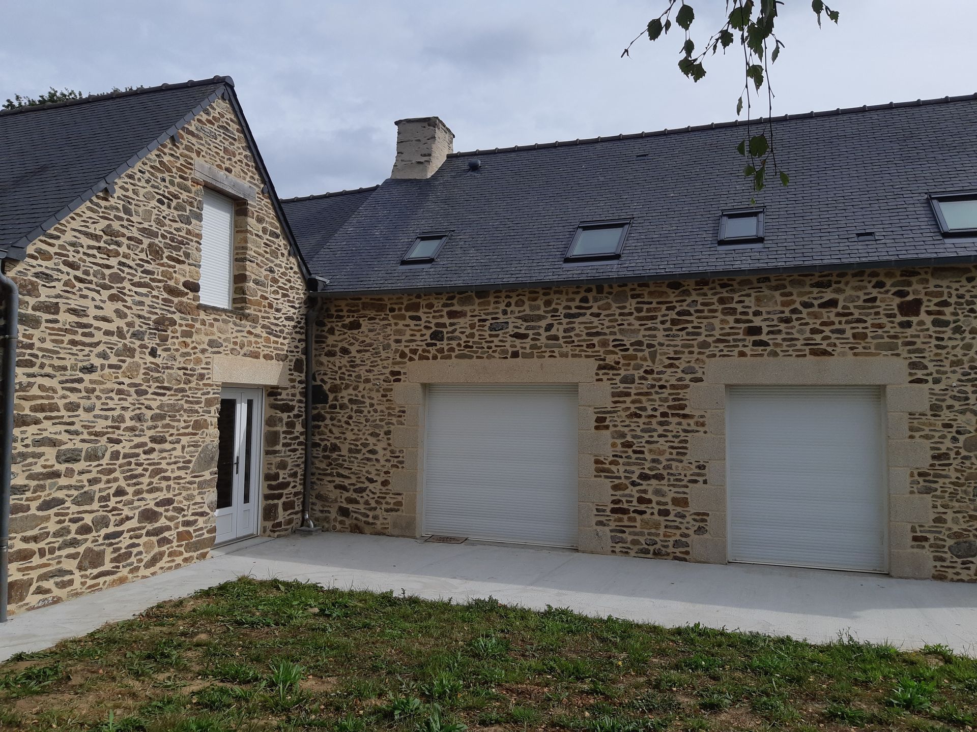 Façade de maison en pierre avec double garage
