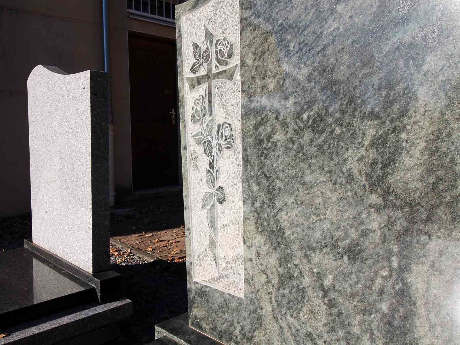 Deux monuments en pierre, l'un orné d'une croix et de motifs floraux, l'autre surmonté d'un sommet incurvé.
