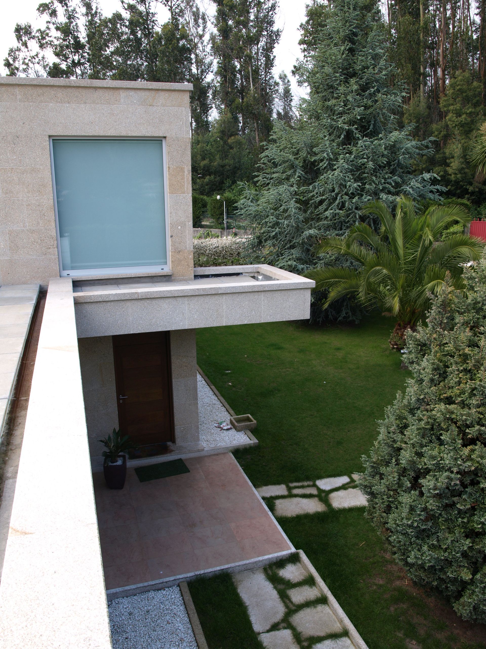 Una casa con un exuberante césped verde y árboles al fondo.