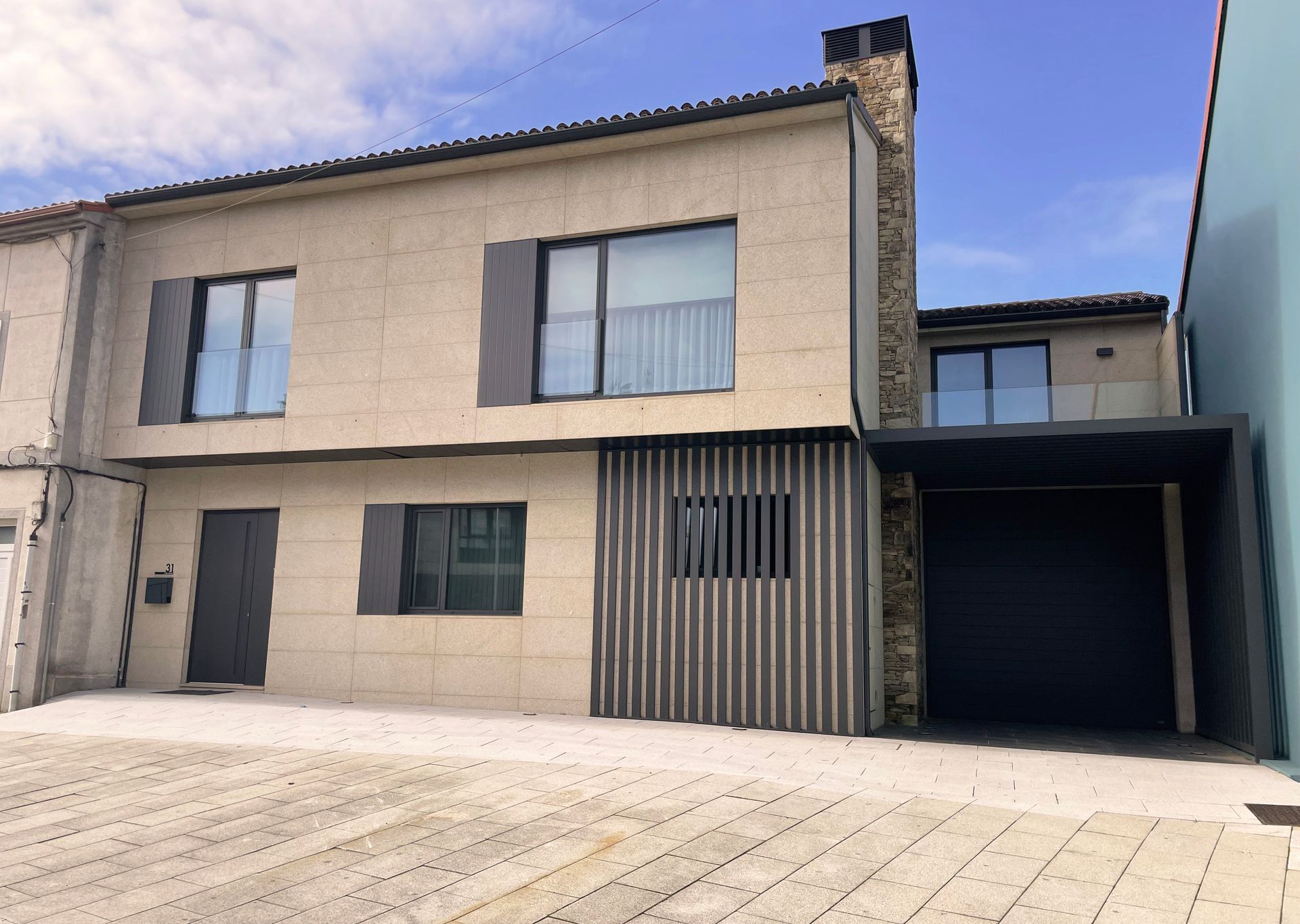 Una casa con muchas ventanas y garaje.