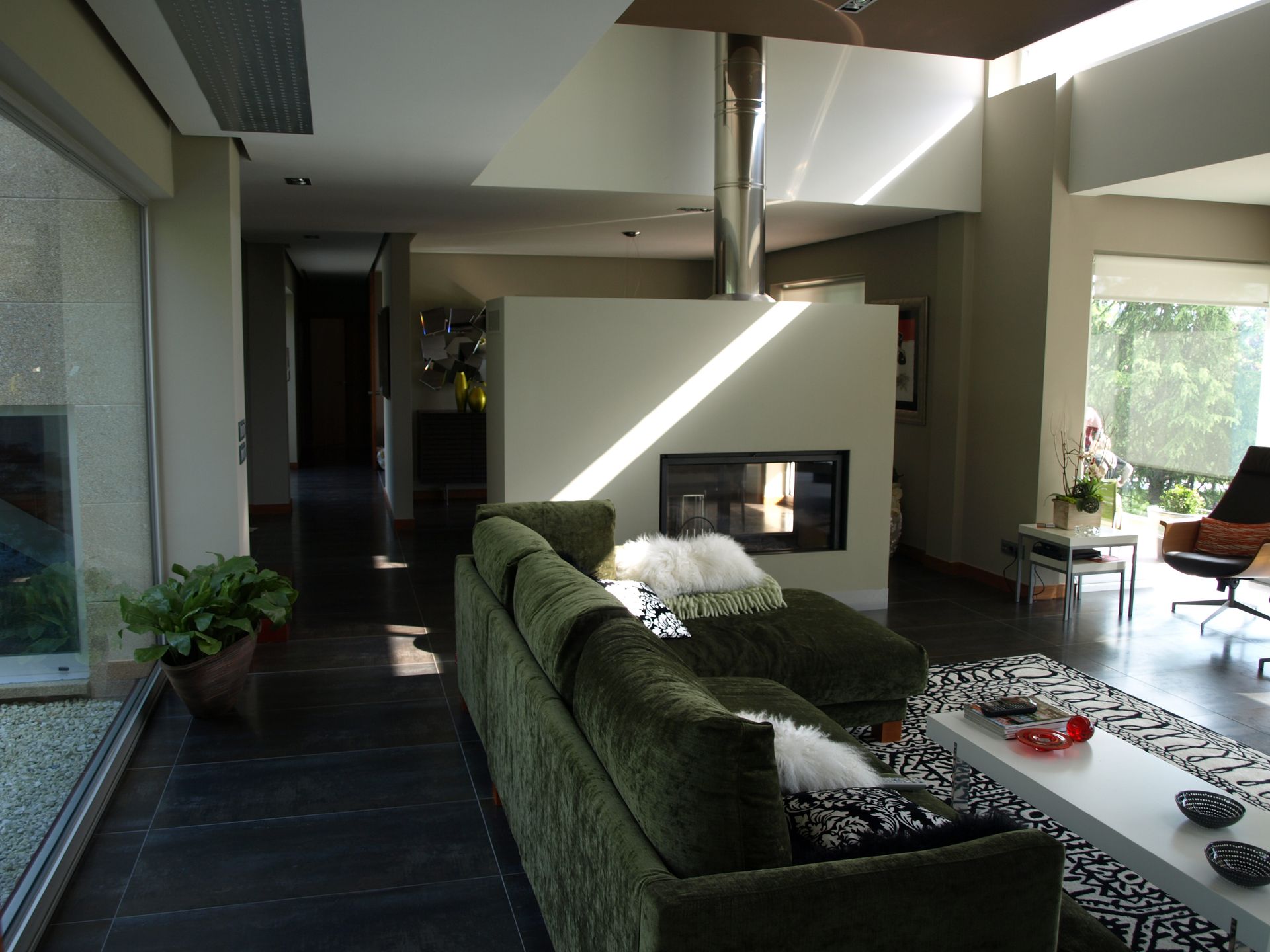 Una sala de estar con un sofá verde y una chimenea.