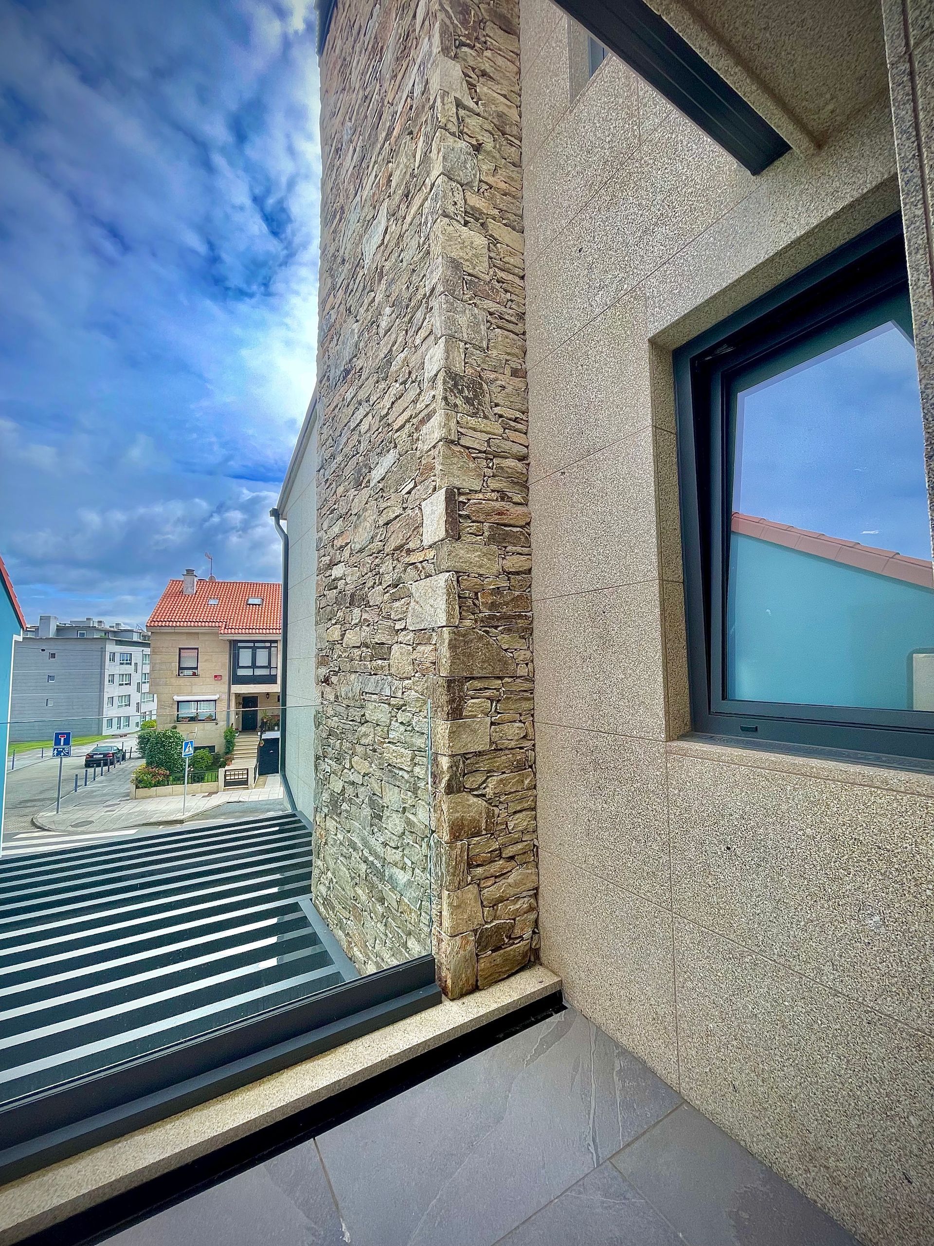 Un balcón con vista a un edificio y una ventana.