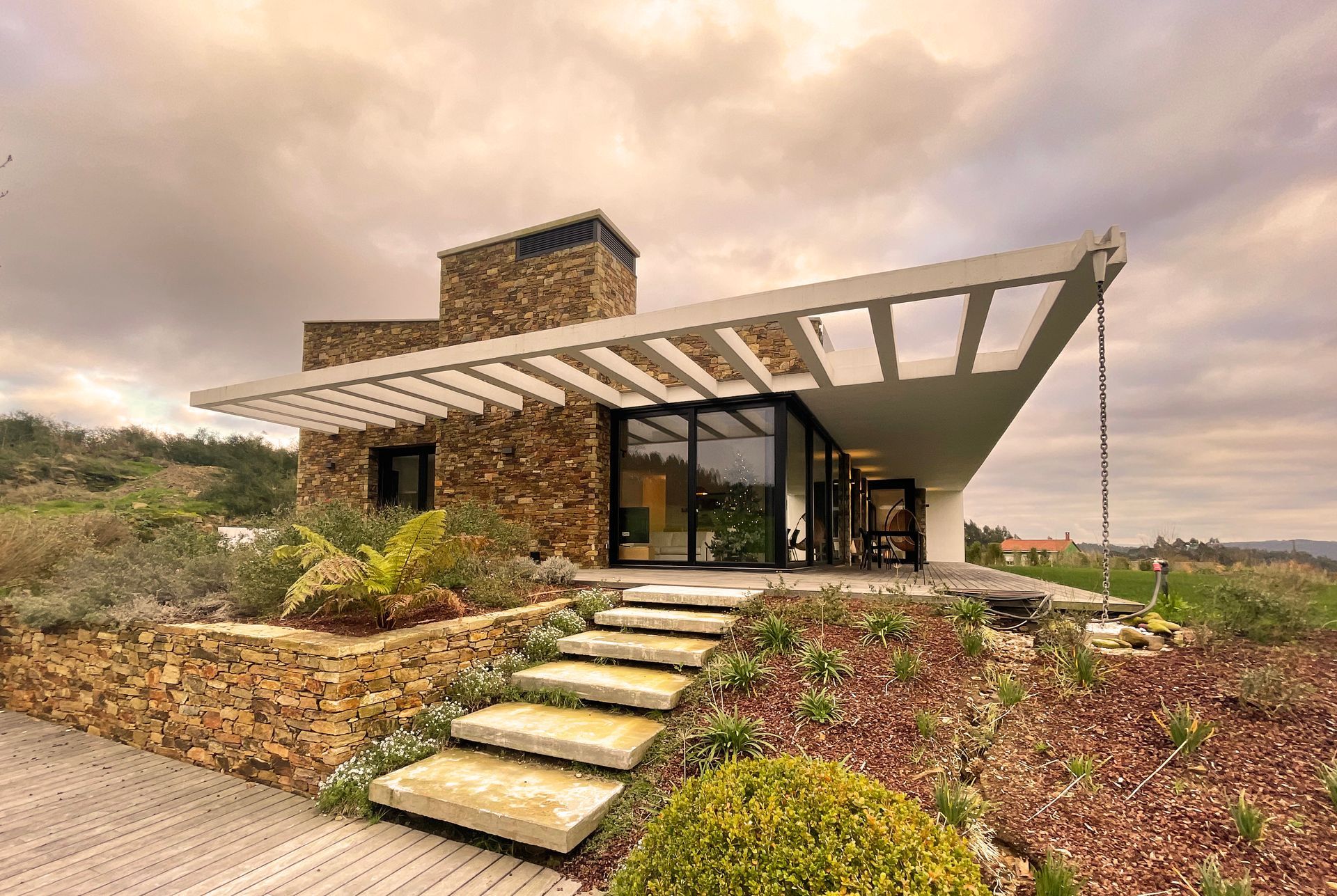 Una casa de piedra moderna con escaleras que conducen a ella.