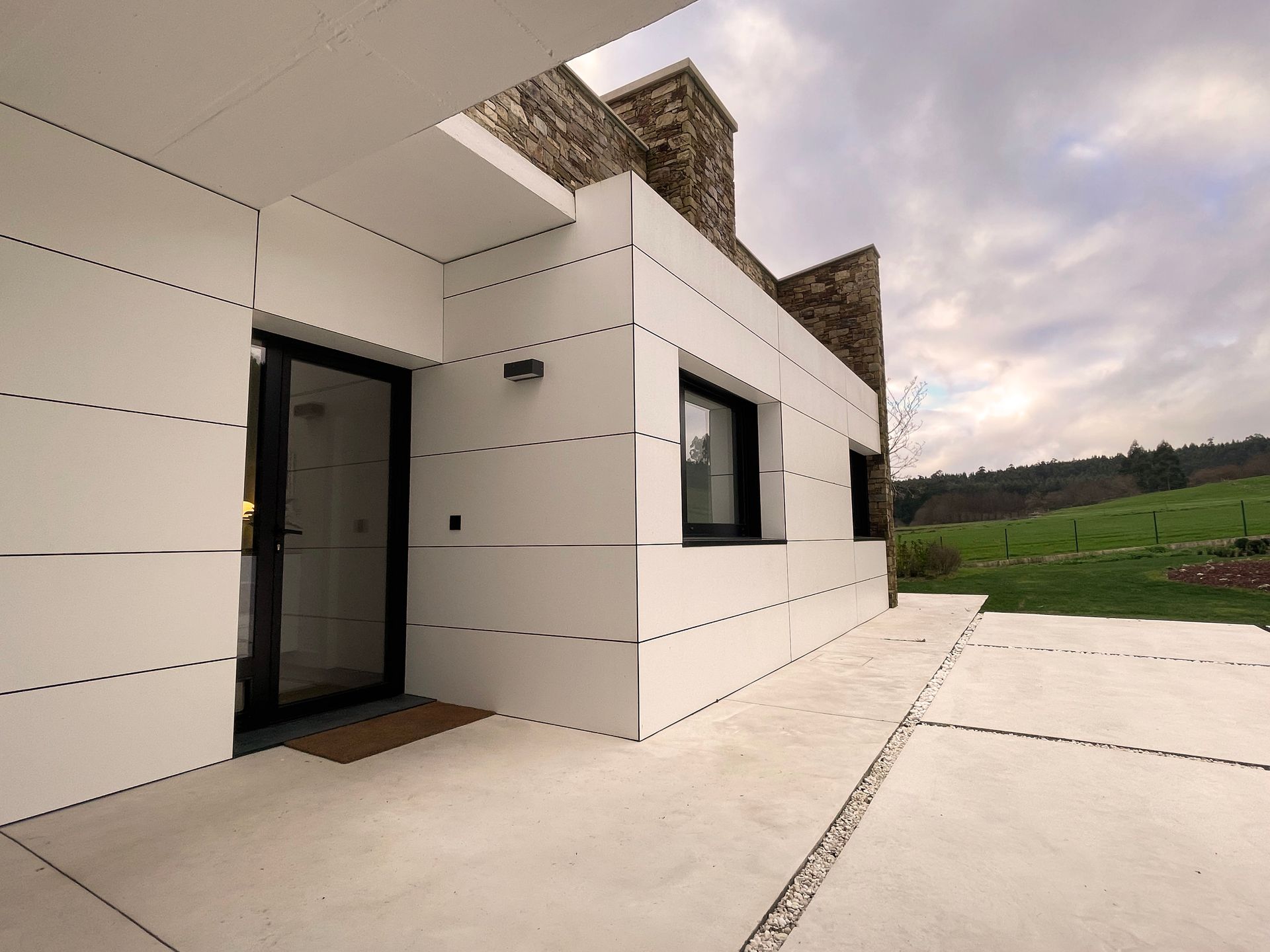 Una casa blanca con una puerta y ventanas negras
