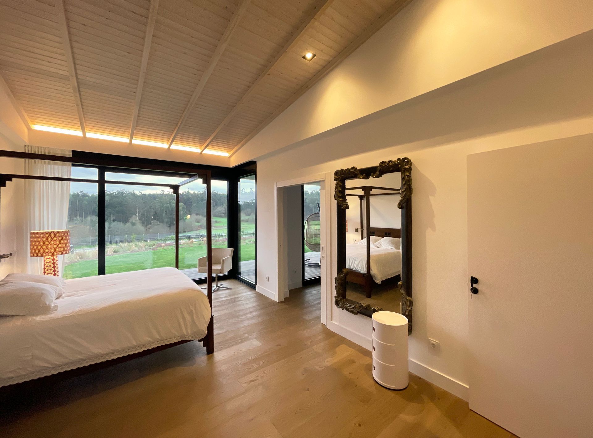 Un dormitorio con una cama con dosel y un gran espejo.