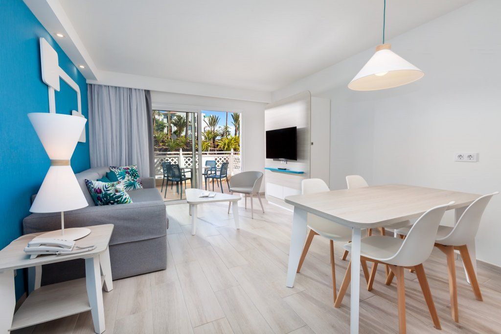 Una sala de estar con sofá, mesa y sillas.