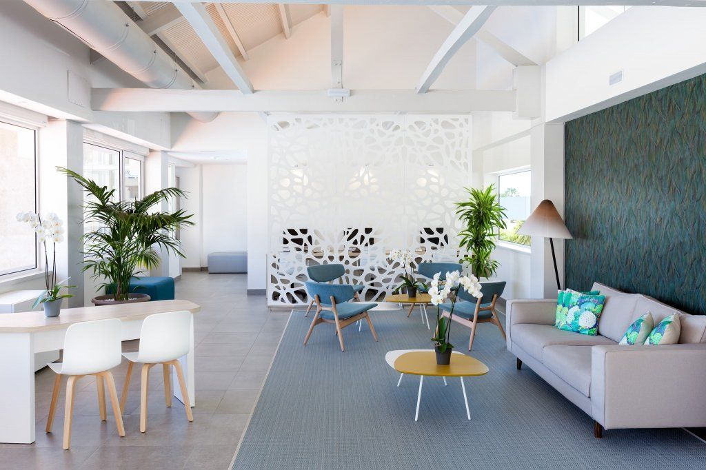 Una sala de estar con un sofá, sillas y una mesa.