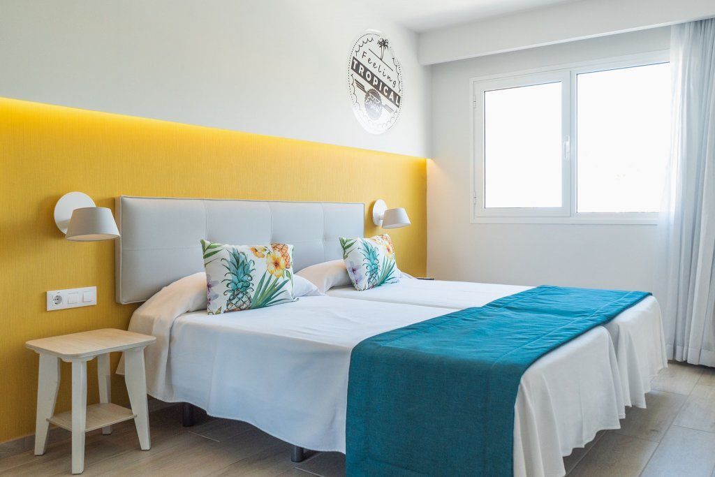 Una habitación de hotel con dos camas y una ventana.