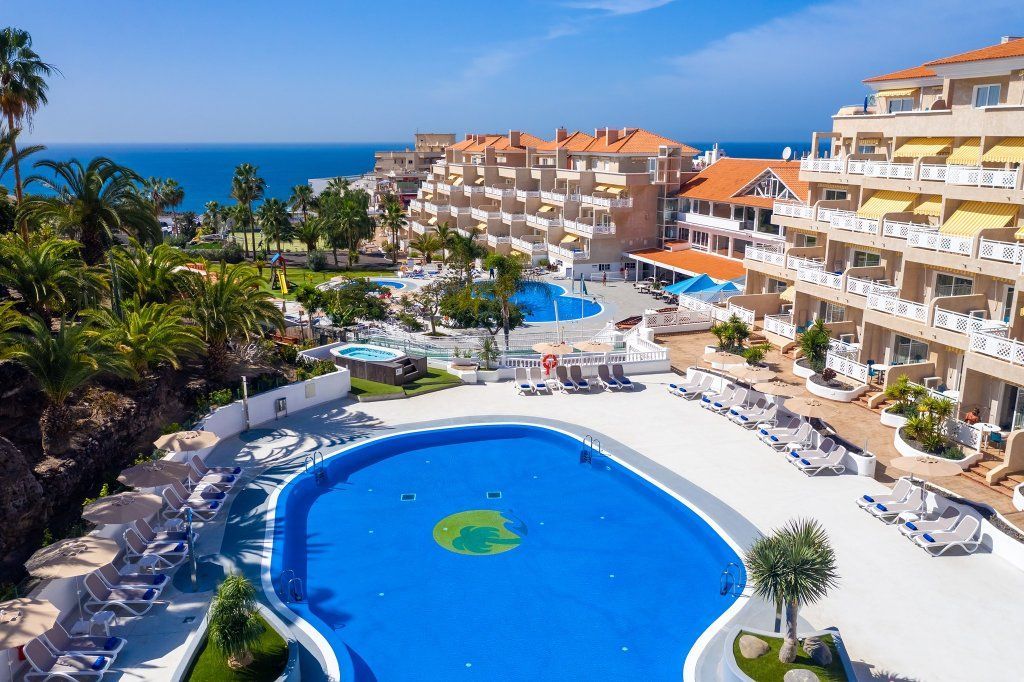 Una vista aérea de una gran piscina frente a un hotel.