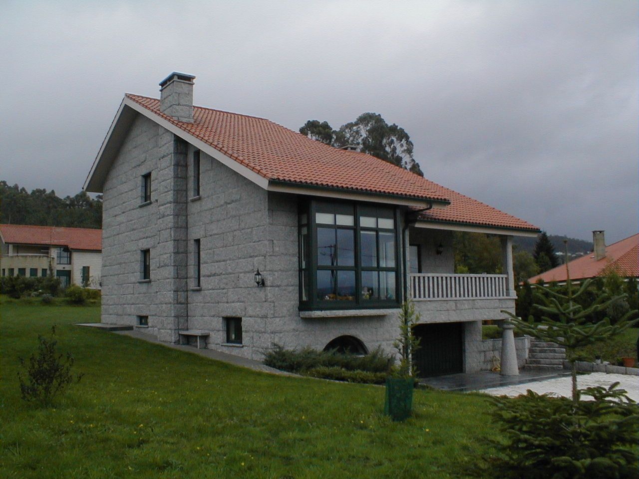 Una gran casa de ladrillo con techo de tejas rojas