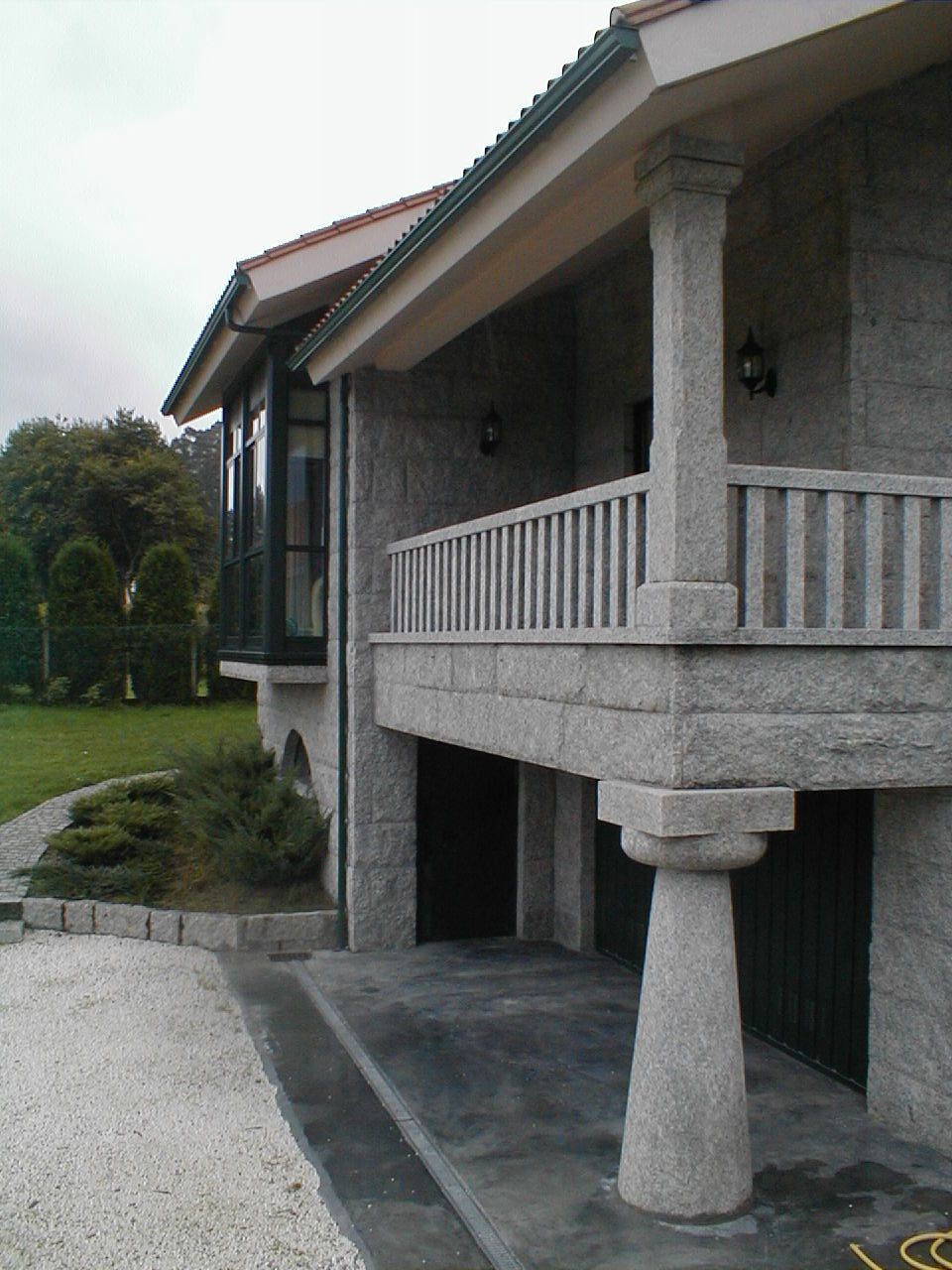 Una gran casa de piedra con balcón y columnas.