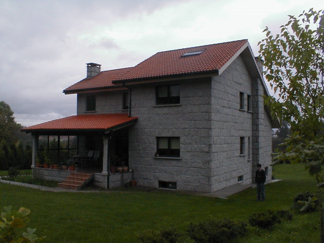 Una gran casa de ladrillo con techo de tejas rojas