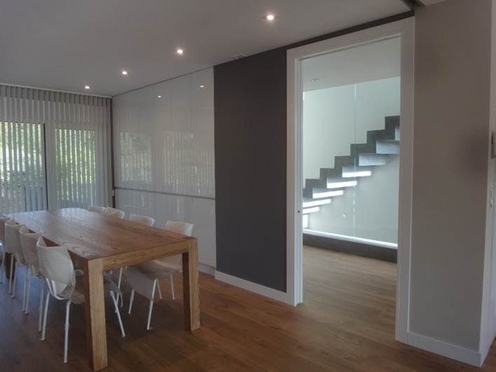 Un comedor con una mesa y sillas junto a una escalera.