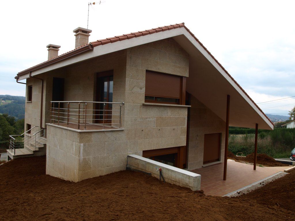 Una casa con techo de tejas rojas y balcón