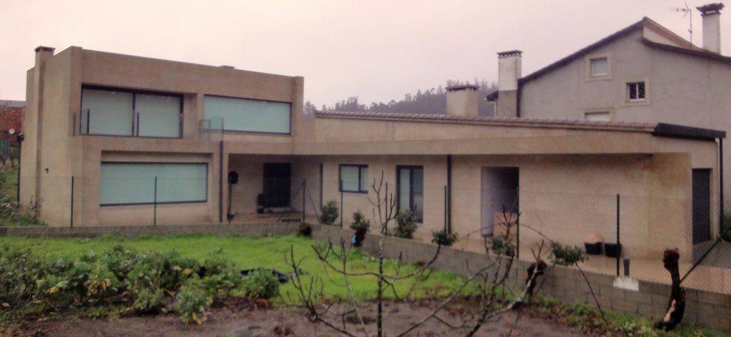 Una casa con muchas ventanas y una valla alrededor.