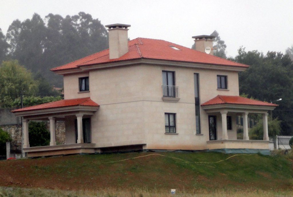 Una gran casa blanca con techo de tejas rojas