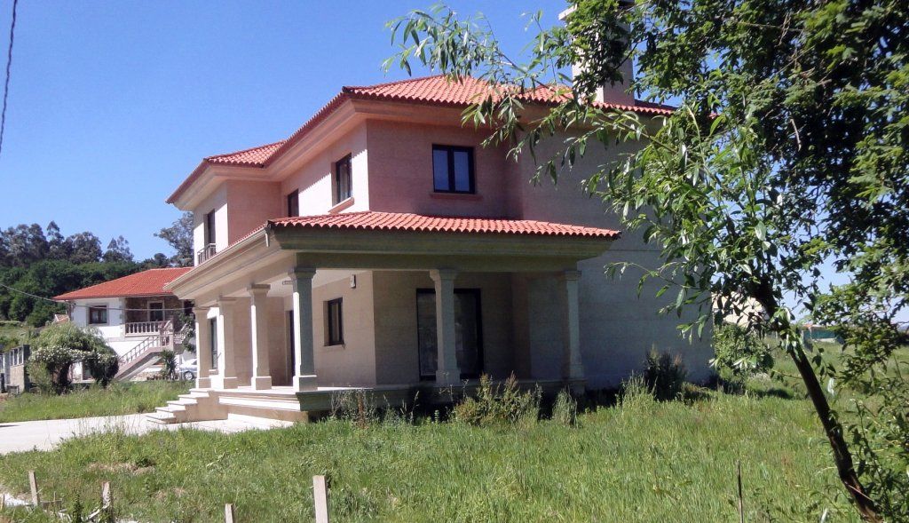 Una gran casa blanca con techo de tejas rojas