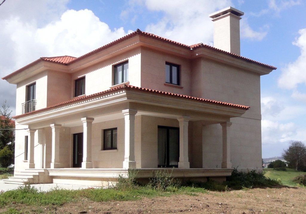 Una gran casa blanca con techo de tejas rojas