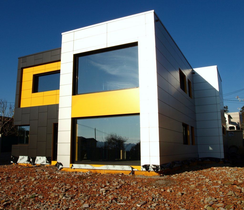 Un edificio blanco y amarillo con muchas ventanas.
