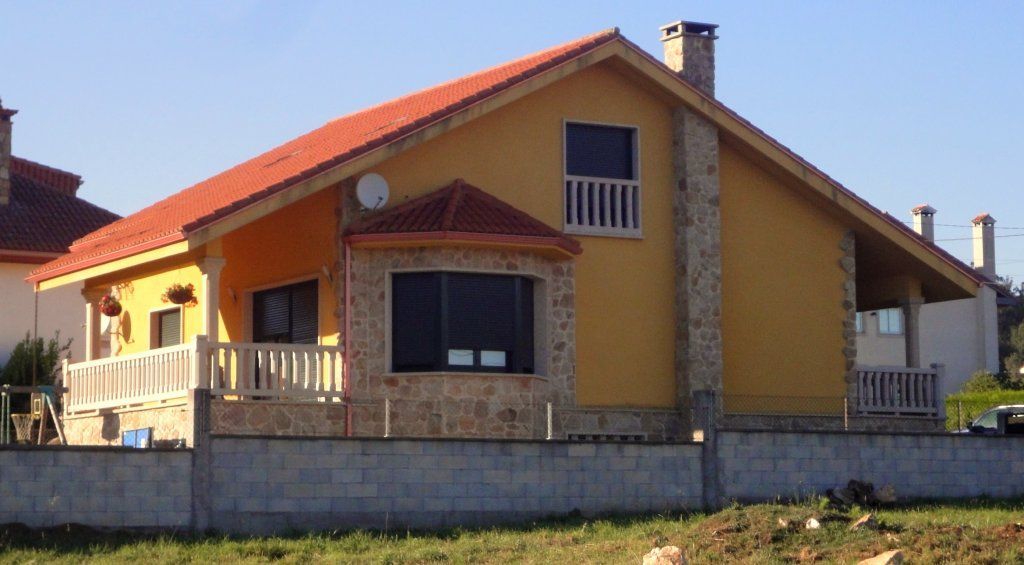 Una casa amarilla con techo de tejas rojas