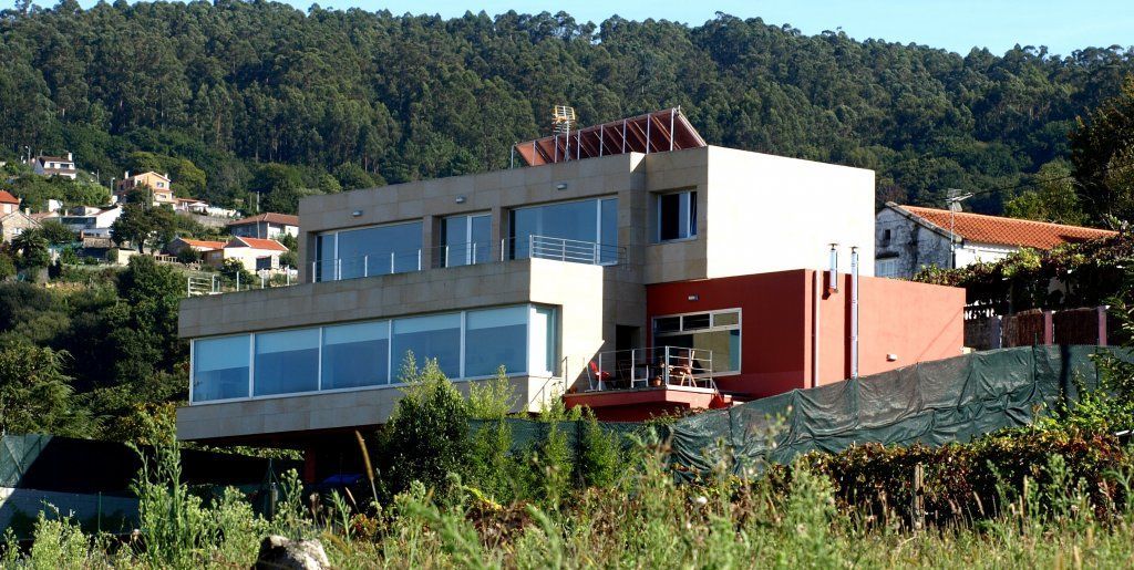 Un gran edificio con muchas ventanas está rodeado de árboles.