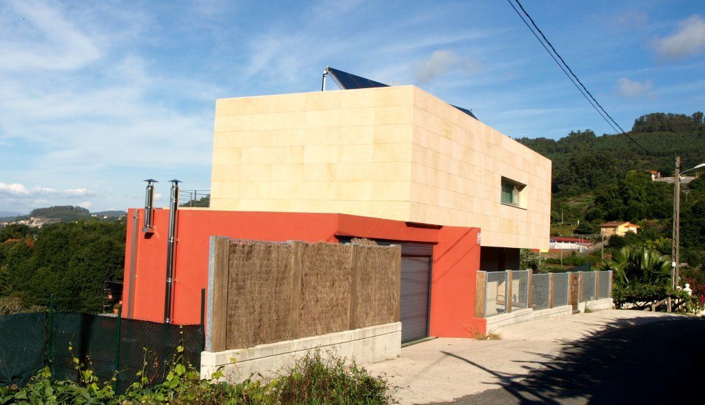 Una casa con una valla y un panel solar en el tejado.
