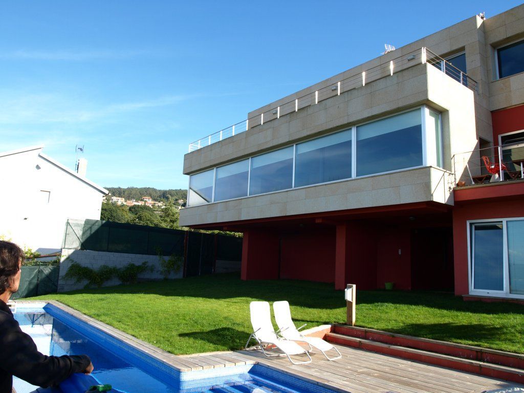 Una casa grande con piscina delante de ella.