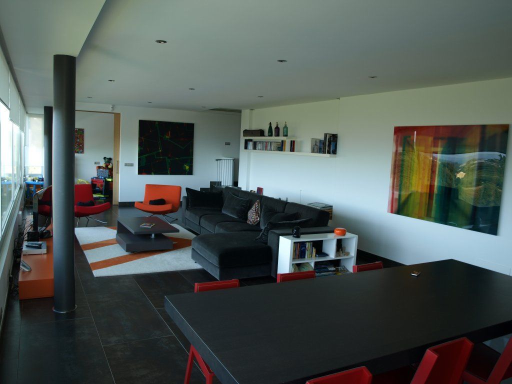 Una sala de estar con un sofá, una mesa y sillas.