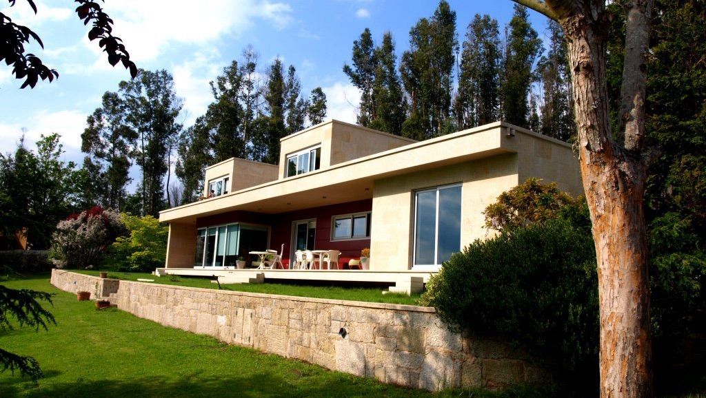 Una casa grande se encuentra en medio de un exuberante bosque verde.