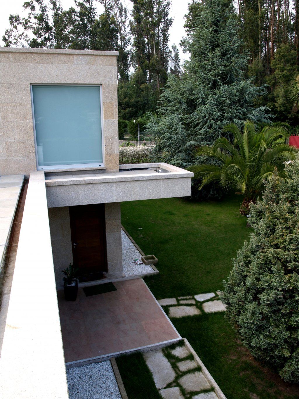 Una vista de una casa desde un balcón con árboles al fondo.