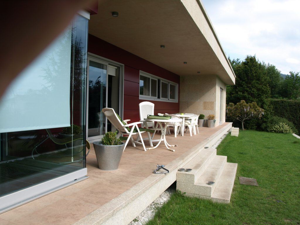 Un patio con una mesa y sillas frente a una casa.