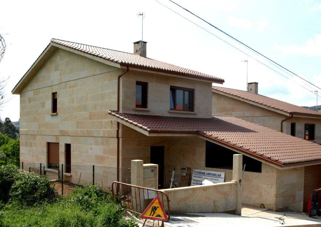 Una casa con techo marrón y un cartel que dice 'atención'