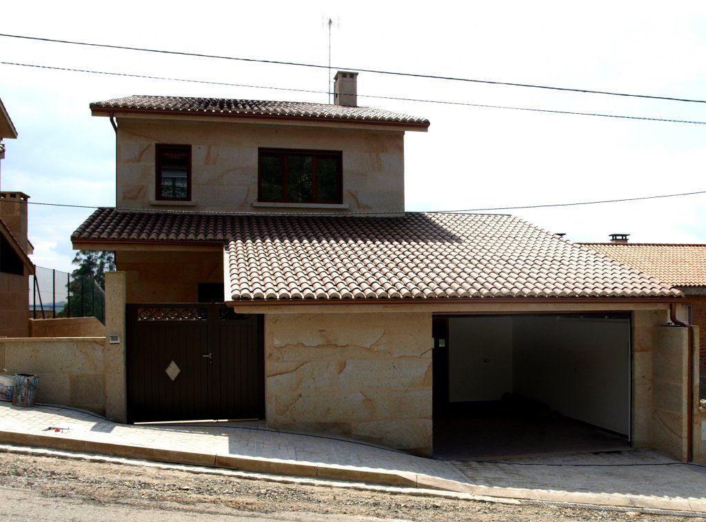 Una casa con techo marrón y garaje