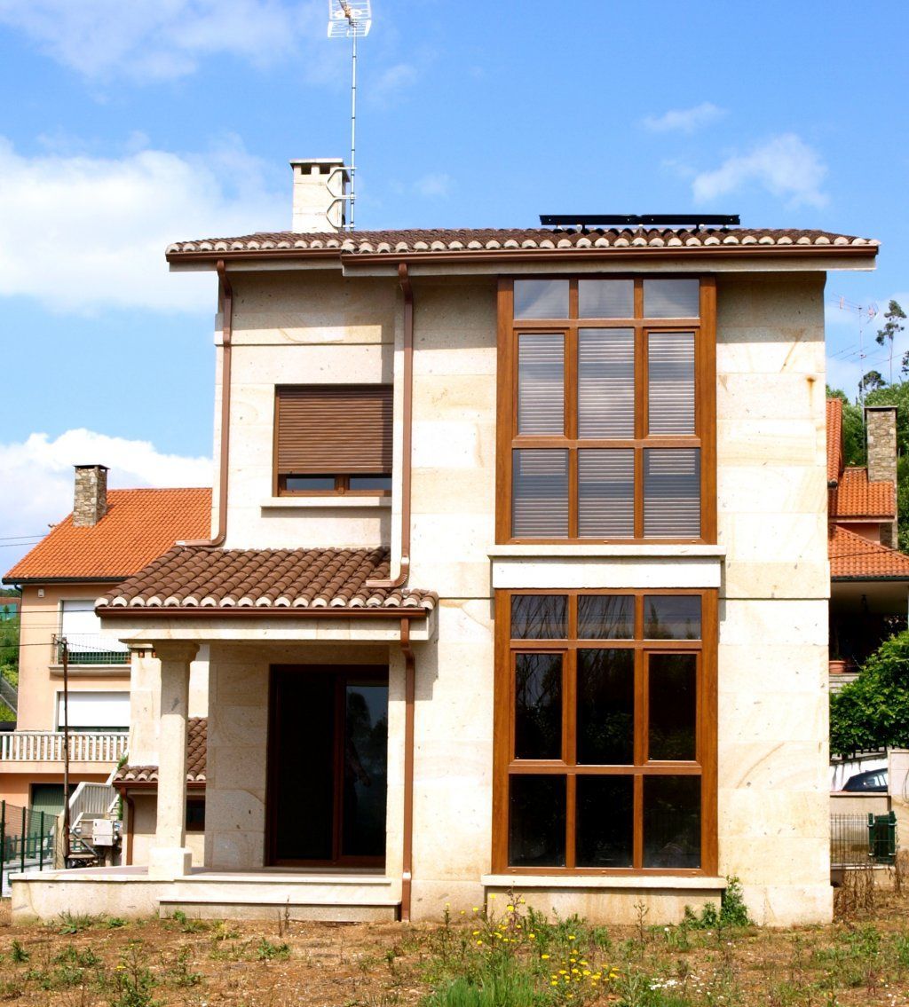 Una casa con muchas ventanas y una chimenea en la parte superior