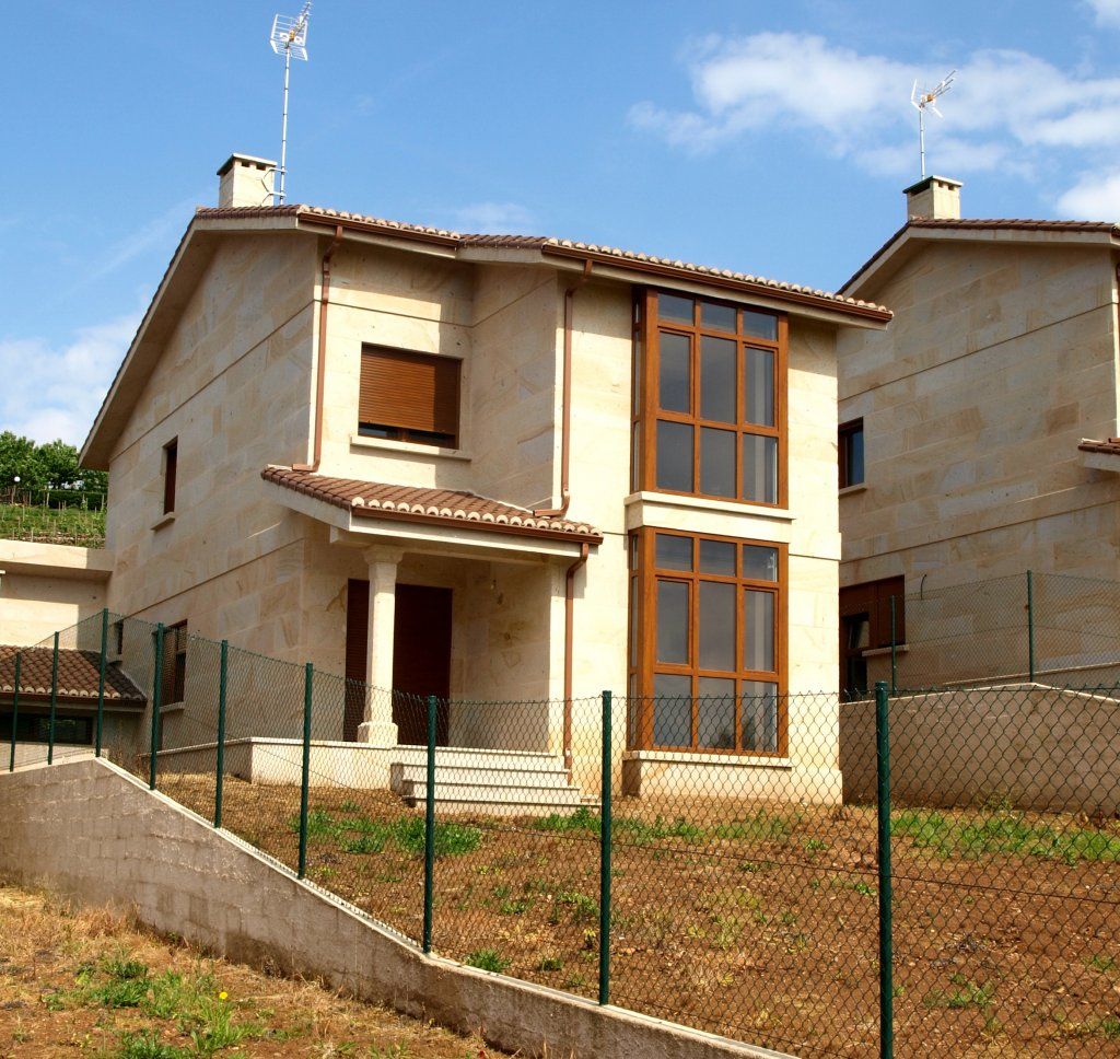 Una casa con una valla alrededor y una antena encima