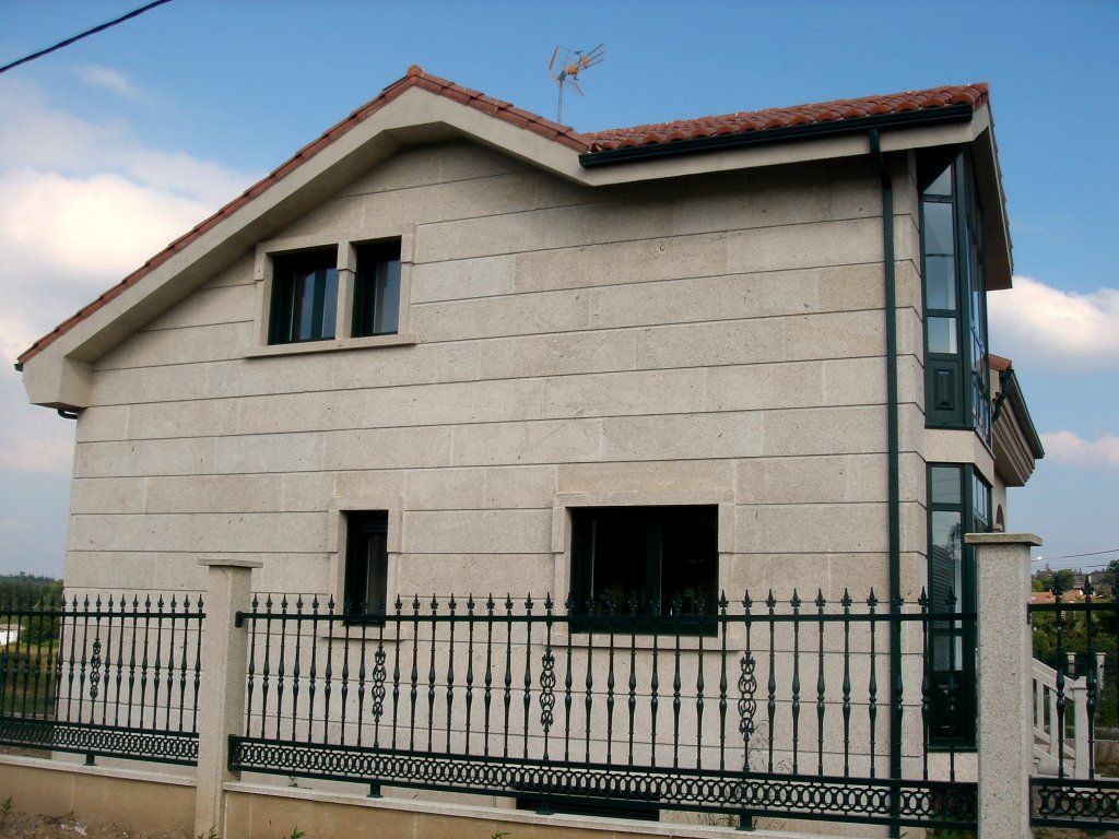 Una casa con una valla negra alrededor