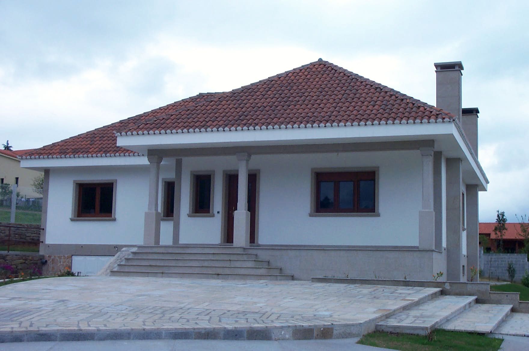 Una casa blanca con techo de tejas rojas