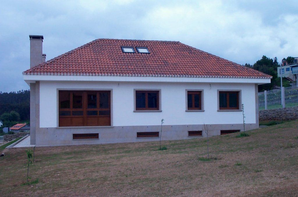 Una casa blanca con techo de tejas rojas
