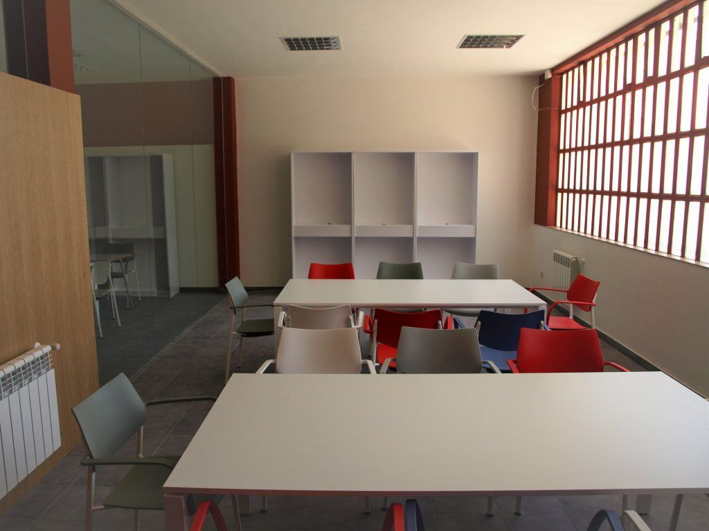 Una habitación con mesas y sillas y un radiador.