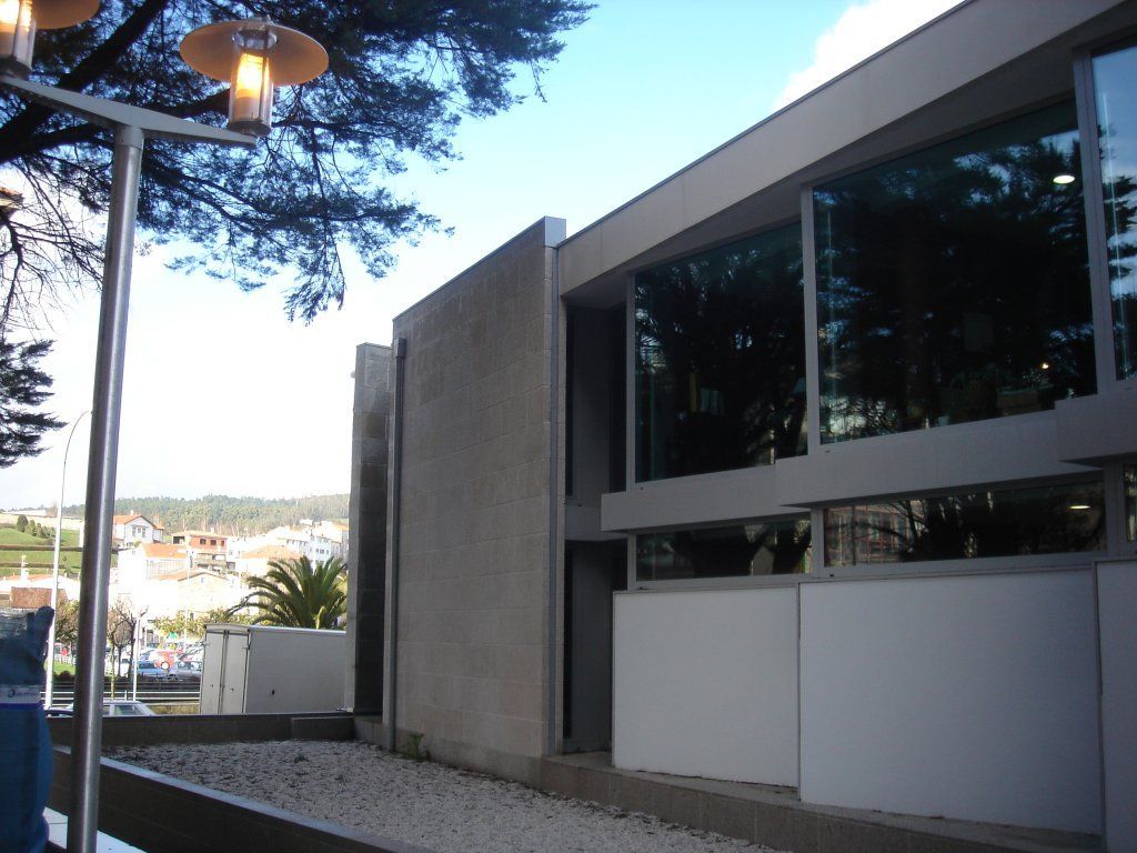 Un edificio con muchas ventanas y una farola delante.