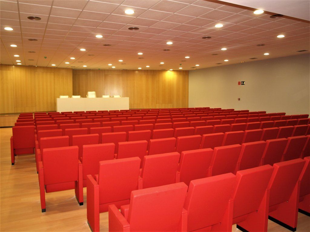 Filas de sillas rojas en un gran auditorio