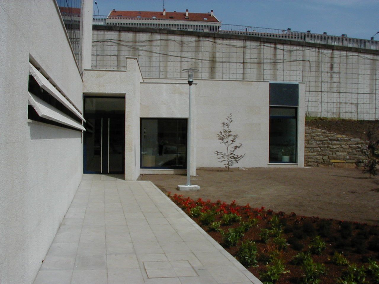 Un edificio blanco con una pasarela que conduce a él.