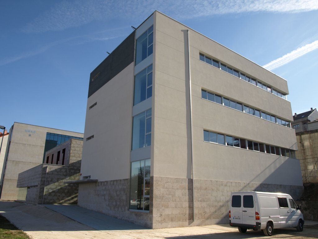 Una camioneta blanca está estacionada frente a un edificio