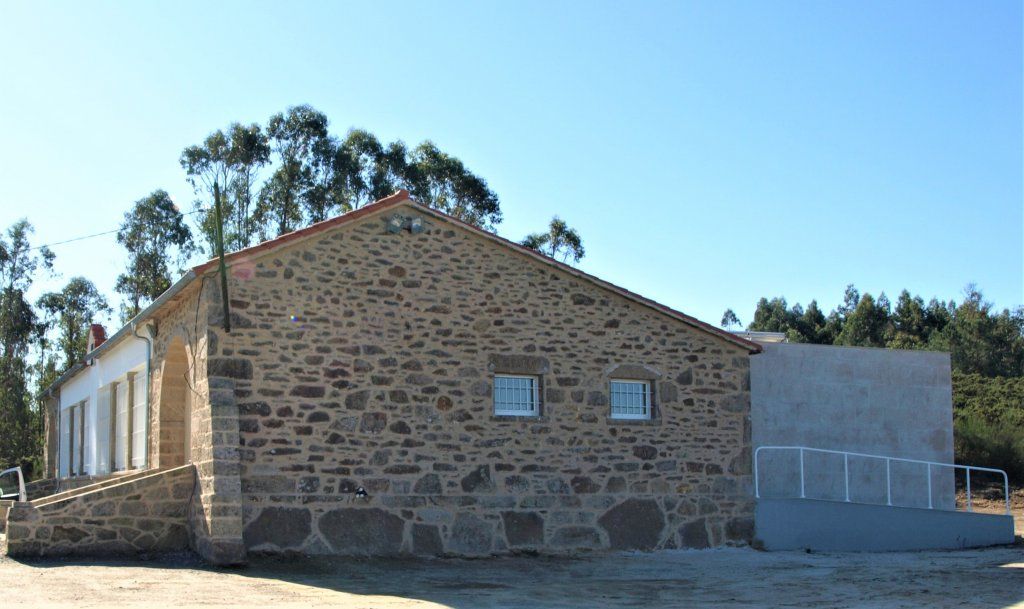 Un edificio de piedra con una rampa delante.
