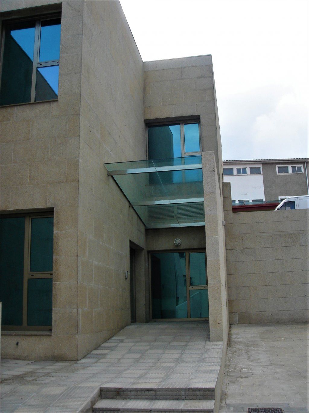 Un edificio con una marquesina de vidrio sobre la entrada