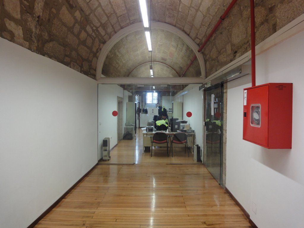 Un largo pasillo con un extintor en la pared.